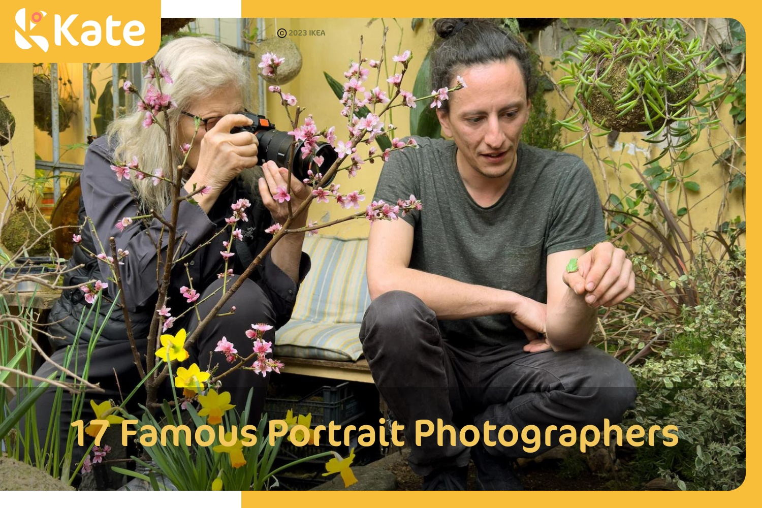 A man and a woman smiling as they take a photo of vibrant flowers in a sunny garden.