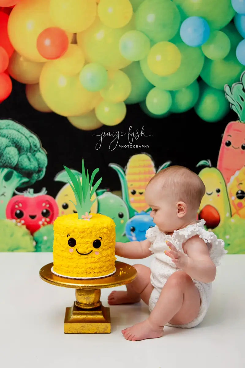 Frutas y verduras de dibujos animados con globos de arcoíris coloridos sobre fondo de pared negra diseñado por Mandy Ringe Photography