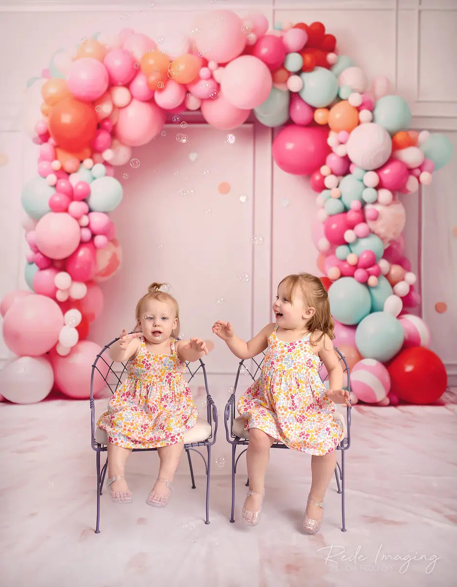 Explosión de pastel de cumpleaños en rosa suave con pared de líneas, arco de globos coloridos y confeti diseñado por Lidia Redekopp